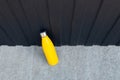 Top view of steel thermo water bottle of yellow color on the concrete floor against metal background of black color Royalty Free Stock Photo