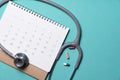 Stethoscope, drug and calendar on the green background, schedule to check up healthy concept