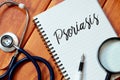 Top view of stethoscope,magnifying glass,pen and notebook written with Psoriasis on wooden background. Health concept. Royalty Free Stock Photo