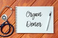Top view of stethoscope,pen and notebook written with Organ Donor on wooden background. Health concept. Royalty Free Stock Photo