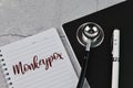 Top view of stethoscope, pen and notebooks written with MONKEYPOX Royalty Free Stock Photo