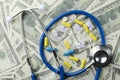 Top view of stethoscope, pills an syringe on the money background.Concept of expensive therapy Royalty Free Stock Photo