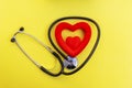 Top view stethoscope and red heart shape on yellow background. For check heart or health check up concept Royalty Free Stock Photo