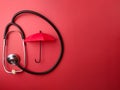 Top view stethoscope and red umbrella on a red background