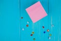 top view of sticky memo note and tiny pin clips on blue background with copy space
