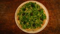 Top view of a still uncooked spinach pizza with olives and grated cheese on a wooden rustic table Royalty Free Stock Photo