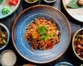 top view of stir fried noodles with vegetables and shrimps in a plate on wooden table Royalty Free Stock Photo