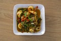 Top view of Stir-Fried Spicy Seafood in white plate on wooden table. Royalty Free Stock Photo