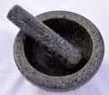 Top view of stone mortar and pestle covered with waterdrops in front of pastel colors in the background