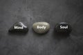 Top view of a stone written with Mind Body Soul on grey background Royalty Free Stock Photo