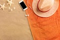 Top view straw hat and smartphone with copy space. Traveler accessories on sand