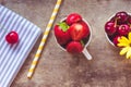 Top view of strawberries, cherries and yellow flowers in bowls with a gray cloth and straw on wooden background Royalty Free Stock Photo