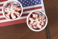 Top view of strawberry sundaes on top of the America flag on a wooden table