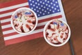Top view of strawberry sundaes on top of the America flag on a wooden table.