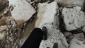 Top view of a stream flowing over stones and a man trying to cross cold water. Clip. First person view of male legs