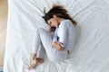 Top view stressed unhappy young woman lying in fetal position Royalty Free Stock Photo