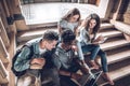 Top view of students who are spending time together.Young people using laptop while sitting on the stairs in the hall university Royalty Free Stock Photo