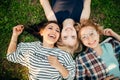 Top view of stylish friends looking at camera and smiling while lying on grass Royalty Free Stock Photo