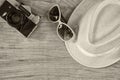 Top View Of Stylish Hat Woman Sunglasses Old Camera Over Wooden Table. Black And White Photo. Vacation And Travel Concept
