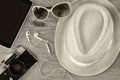 Top view of stylish hat woman sunglasses old camera and tablet device over wooden table. black and white photo. vacation and Royalty Free Stock Photo