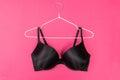 Top view of stylish women bra on white hanger on pink background with copy space. Women`s wardrobe Royalty Free Stock Photo