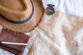 Top view of Summer brown panama straw hat,mobile,notebook map,compass on linen cloth.vacation travel concept.copy space for adding