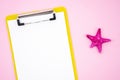 Top view summer clipboard mockup with a blank piece of paper and starfish on pink background. Flat lay with copy space Royalty Free Stock Photo