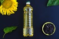 Sunflower oil with flower and seeds in a bottle on black background Royalty Free Stock Photo