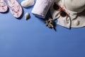 Top view of sunglasses, a straw hat, sandals, a towel and sea shells on a blue background Royalty Free Stock Photo