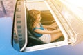 Top view from sunroof of a young beautiful woman sitting on car seat and drive carefuly.