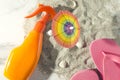 Top view of sunscreen,flip flop,little beach umbrella on sandy shore.Warm colors Royalty Free Stock Photo