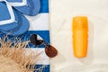 Top view of sunscreen, straw hat, flip flops, sunglasses and striped blue and white towel on golden sand. Royalty Free Stock Photo