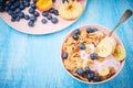 Healthy breakfast bowl berry greek yoghurt with frefh blueberries, banana and flakes on the blue wooden table Royalty Free Stock Photo