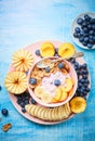 Healthy breakfast bowl berry greek yoghurt with frefh blueberries, banana and flakes on the blue wooden table Royalty Free Stock Photo