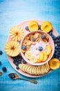 Healthy breakfast bowl berry greek yoghurt with frefh blueberries, banana and flakes on the blue wooden table Royalty Free Stock Photo