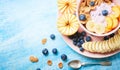 Healthy breakfast bowl berry greek yoghurt with frefh blueberries, banana and flakes on the blue wooden table Royalty Free Stock Photo