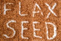 Top view. The surface of the heap of flaxseeds. Caption: Flaxseed. White background. Close up, macro Royalty Free Stock Photo