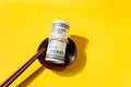 Top view sushi roll of dollars is tightened with a rubber band and sushi sticks on a yellow background Royalty Free Stock Photo