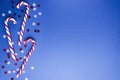 Top view of candy canes, confetti on the blue background, empty space for text Royalty Free Stock Photo