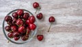 Top view on sweet cherries in a glass bowl on wooden background Royalty Free Stock Photo