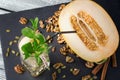 Top view of a sweet, organic melon on a dark background. A glass of honeydew, ice and mint. A composition of healthy ingredients. Royalty Free Stock Photo