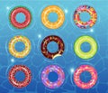 Top view swimming pool with colorful inflatable rubber rings. Swim rings set on a sea background. Summer vacation or Royalty Free Stock Photo