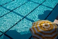 Top view swimming pool with yellow parasol beach umbrella in summer vacation concept blue water background Royalty Free Stock Photo