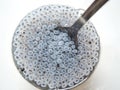 Top view of swollen Chia seeds in a glass with water and a spoon.