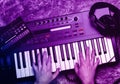 Top view of synthesizer keyboard piano with male hands in neon light. Royalty Free Stock Photo