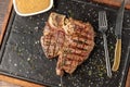 Top view of T-Bone Steak served on stone plate with sauce on the side Royalty Free Stock Photo