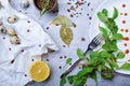 Top view of a table with bay leaves, green salad leaves, quail eggs, a half of lemon on a light gray background.