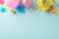 Top view of a table decked out with gift, birthday hat, pipe, candles, balloons, candies and confetti on blue surface Royalty Free Stock Photo