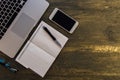 Top view of table or desk with laptop, blank notebook, pen and smart phone on old bronze background Royalty Free Stock Photo