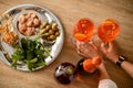 Top view on the table with glasses of cold bright orange drink which female hands hold Royalty Free Stock Photo